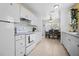 Well-lit kitchen with white cabinets, modern appliances, and tiled backsplash at 6936 77Th N Ter, Pinellas Park, FL 33781
