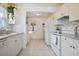 Clean kitchen featuring white appliances, cabinets, and access to laundry area at 6936 77Th N Ter, Pinellas Park, FL 33781