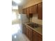 Kitchen features wooden cabinets, a stainless steel double sink, and tile flooring with an adjacent dining area at 7507 Presley Pl # D, Tampa, FL 33617