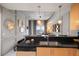 Modern kitchen featuring black countertops, stainless steel sink, and dishwasher, plus a partial view of the living room at 777 N Ashley Dr # 1516, Tampa, FL 33602