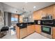 Kitchen with light wood cabinets, stainless steel appliances, black backsplash, and adjacent living space at 777 N Ashley Dr # 1516, Tampa, FL 33602