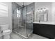 This bathroom features a glass shower, gray tile, and a modern vanity with white countertop and black fixtures at 806 W Adalee St, Tampa, FL 33603