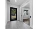 Inviting foyer featuring sleek tiled flooring, a modern front door, and a sliding barn door at 806 W Adalee St, Tampa, FL 33603