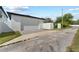 Detached garage with a white exterior, brick paver driveway, and white fence at 806 W Adalee St, Tampa, FL 33603