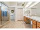 Bathroom with a large vanity with double sinks, tiled floors, and a glass-enclosed shower at 9008 Quail Creek Dr, Tampa, FL 33647