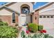 Inviting home's front entrance with brick accents, arched window, and flourishing rose bushes at 9008 Quail Creek Dr, Tampa, FL 33647