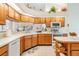 Well-lit kitchen with wood cabinetry and modern white appliances overlooking the pool at 9008 Quail Creek Dr, Tampa, FL 33647