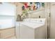 Functional laundry room with a washer, dryer, and ample shelving for storage at 9008 Quail Creek Dr, Tampa, FL 33647