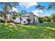 Charming single-story home featuring stone details, manicured lawn, and lush landscaping at 9107 Bay Ne St, St Petersburg, FL 33702