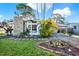 Inviting single-story home featuring a stone chimney, large windows, and a covered carport at 9107 Bay Ne St, St Petersburg, FL 33702