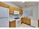Functional kitchen features white appliances, light wood cabinetry, and light countertop at 9516 Amberdale Ct # 202, Riverview, FL 33569