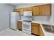 Functional kitchen features white appliances, light wood cabinetry, and light countertop at 9516 Amberdale Ct # 202, Riverview, FL 33569