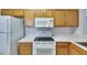 Functional kitchen features white appliances, light wood cabinetry, and light countertop at 9516 Amberdale Ct # 202, Riverview, FL 33569