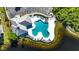 Aerial view showcasing the uniquely shaped community pool with plenty of lounge seating near a small lake at 9516 Amberdale Ct # 202, Riverview, FL 33569