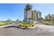 View of the gated entry to a luxury condo building, beautifully landscaped with tropical palms and manicured shrubs at 10851 Mangrove Cay Ne Ln # 714, St Petersburg, FL 33716