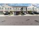 View of townhomes with gray exteriors, dark shutters, driveways, and well-manicured lawns at 10924 Brightleaf Ct, Riverview, FL 33569