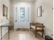 Inviting foyer with tile flooring, decorative mirror, and bench seating at 11225 Godwit Ct, New Port Richey, FL 34654