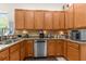 Kitchen featuring ample wood cabinetry, granite countertops, stainless steel appliances, and tile backsplash at 11225 Godwit Ct, New Port Richey, FL 34654