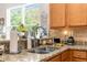 Close up of kitchen sink featuring granite countertops, stainless steel faucet, and view of the outdoors at 11225 Godwit Ct, New Port Richey, FL 34654