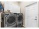 Laundry room featuring new washer and dryer appliances, tiled floor, and lots of cabinets for storage at 11225 Godwit Ct, New Port Richey, FL 34654