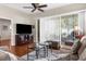 Comfortable living room with a ceiling fan, neutral paint colors, wood floor, and glass sliding door leading to outdoor patio at 11225 Godwit Ct, New Port Richey, FL 34654
