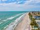 Beautiful coastal aerial view of a white sandy beach and clear turquoise water showcasing homes and nearby condominiums at 11549 48Th Ave N, St Petersburg, FL 33708