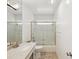 Bright bathroom with decorative glass shower door, granite countertop, and modern lighting fixture at 11549 48Th Ave N, St Petersburg, FL 33708