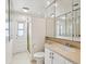 Bright bathroom featuring toilet, sink, vanity, shower, and door access at 11549 48Th Ave N, St Petersburg, FL 33708