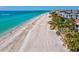 Gorgeous beach view featuring a white sandy beach, clear turquoise water, and nearby condo communities at 11549 48Th Ave N, St Petersburg, FL 33708