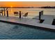 Stunning waterfront sunset view from the private dock with seating area, perfect for relaxing by the pool at 11549 48Th Ave N, St Petersburg, FL 33708