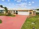Charming waterfront home featuring an attached garage and colorful red driveway at 11549 48Th Ave N, St Petersburg, FL 33708