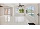 Bright living room with tile floors, ceiling fan, and large windows showcasing outdoor pool at 11549 48Th Ave N, St Petersburg, FL 33708