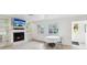 Bright living room featuring a fireplace with mounted TV, tile flooring, and views from large windows at 11549 48Th Ave N, St Petersburg, FL 33708