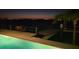 Night view showcases a waterfront pool, dock, and outdoor seating area with calm waters in the background at 11549 48Th Ave N, St Petersburg, FL 33708