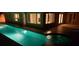 Beautiful long pool with underwater lighting against the house with many windows at night at 11549 48Th Ave N, St Petersburg, FL 33708
