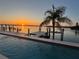 Relaxing poolside view at sunset with a dock, waterfront access, and palm trees at 11549 48Th Ave N, St Petersburg, FL 33708