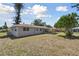 Home exterior featuring a covered patio and a spacious backyard with mature trees at 1165 63Rd S Ave, St Petersburg, FL 33705