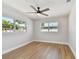 Bright bedroom featuring wood-look floors, a ceiling fan, and two windows for natural light at 1165 63Rd S Ave, St Petersburg, FL 33705