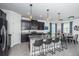 Modern kitchen featuring dark cabinets, granite countertops, stainless steel appliances, and a breakfast bar at 12315 Dora Trail, Parrish, FL 34219