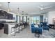 Spacious open-concept living area with a bar, tile flooring, comfortable seating, and sliding glass doors at 12315 Dora Trail, Parrish, FL 34219