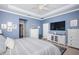 A large primary bedroom features blue walls, a ceiling fan, and an ensuite bathroom at 12315 Dora Trail, Parrish, FL 34219