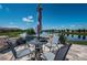 Charming patio area with comfortable seating, umbrella, and scenic lake views perfect for relaxing outdoors at 12315 Dora Trail, Parrish, FL 34219