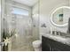Modern bathroom features glass-enclosed shower, granite countertop, and illuminated mirror at 12409 Gentle Swan Pl, Odessa, FL 33556