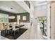 Open-concept living area with dining space, high ceilings, modern lighting, and seamless access to outdoor pool area at 12409 Gentle Swan Pl, Odessa, FL 33556
