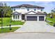 Stately two-story home showcasing a manicured lawn, three car garage, and stone accents at 12409 Gentle Swan Pl, Odessa, FL 33556