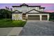 Elegant two-story home featuring a stone facade, a well-manicured lawn, and a spacious three-car garage at 12409 Gentle Swan Pl, Odessa, FL 33556