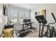 Bright office space with large windows, plantation shutters, modern desk setup, and workout equipment at 12409 Gentle Swan Pl, Odessa, FL 33556