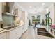 Bright modern kitchen features an island with bar seating, stainless steel appliances, and a view of the dining area at 12409 Gentle Swan Pl, Odessa, FL 33556