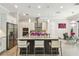 Bright kitchen features an island with granite countertops, bar stools, and stainless-steel appliances at 12409 Gentle Swan Pl, Odessa, FL 33556