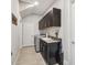 Well-organized laundry room features modern washer, dryer, sink, stylish cabinets, and a granite countertop at 12409 Gentle Swan Pl, Odessa, FL 33556